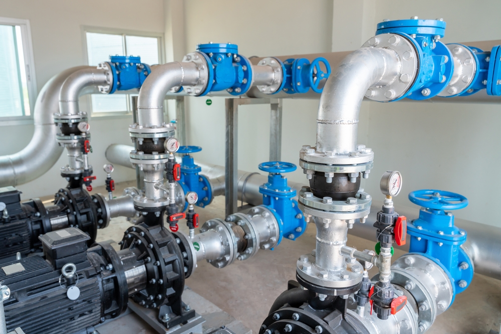 Commercial plumber inspecting Poly-B piping system in a business facility in Orillia or North Bay