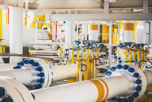 Commercial plumber repairing industrial pipes in a facility in Orillia or North Bay