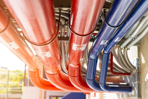 Technician performing routine plumbing maintenance in a commercial facility