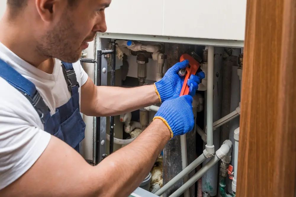 Plumber inspecting basement drain after signs of sewage backup in a commercial or residential building
