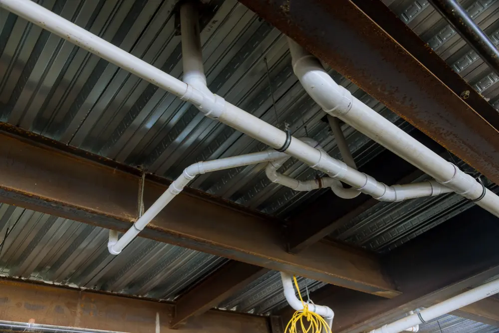 Plumber completing rough-in installations at a commercial site in Orillia or North Bay
