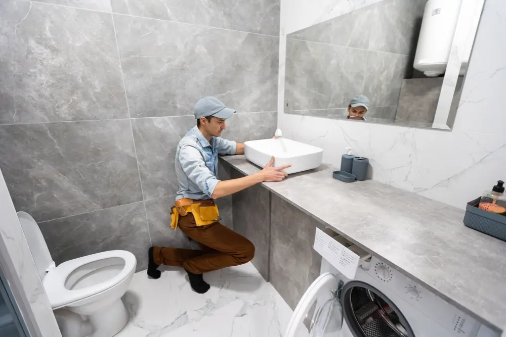 Plumber replacing old pipes and rerouting plumbing during a commercial renovation