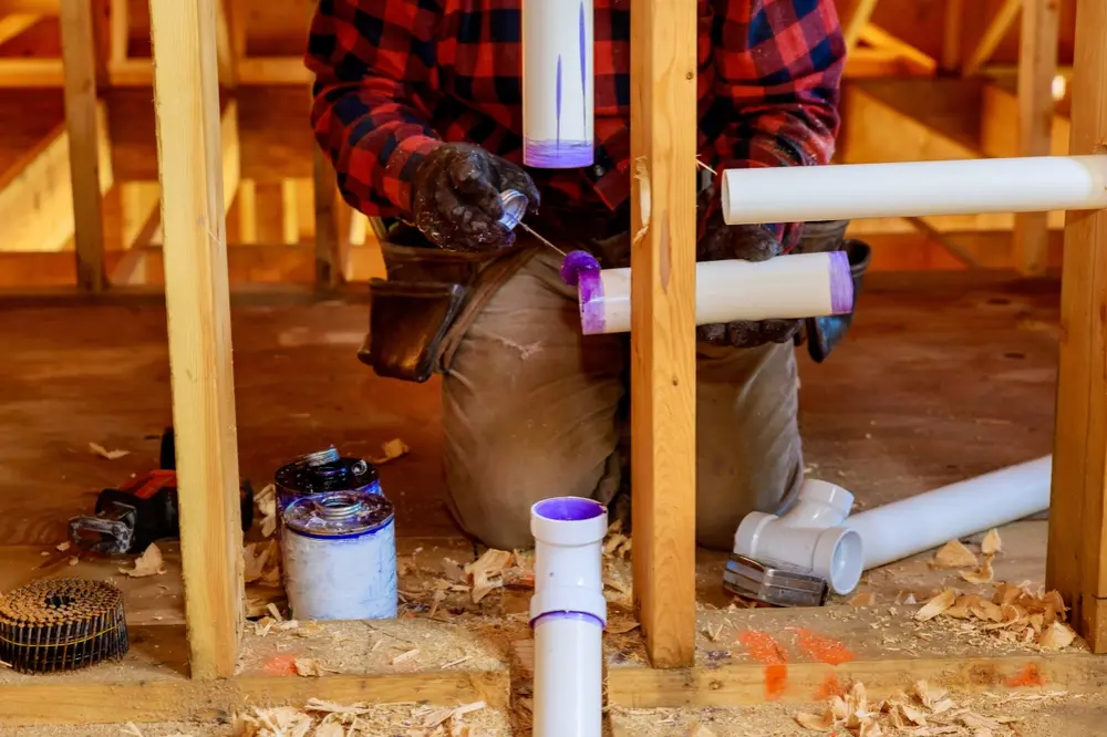 Poly-B Plumbing team meeting with a builder and homeowner on a residential construction site
