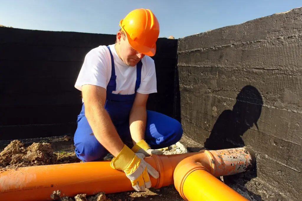 Plumber assessing repeated pipe repairs in an aging commercial plumbing system