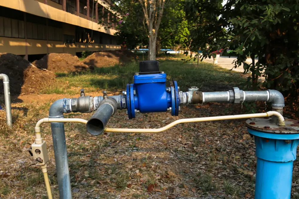 Technician inspecting an aging submersible well pump system at a rural property