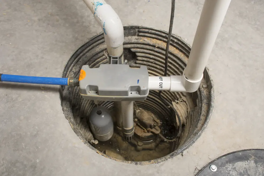 Plumber inspecting an old sump pump system showing signs of failure in a residential basement