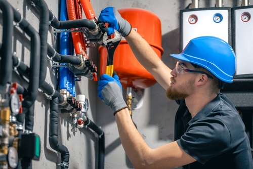 Plumber reviewing installation plans and preparing tools at a residential or commercial job site