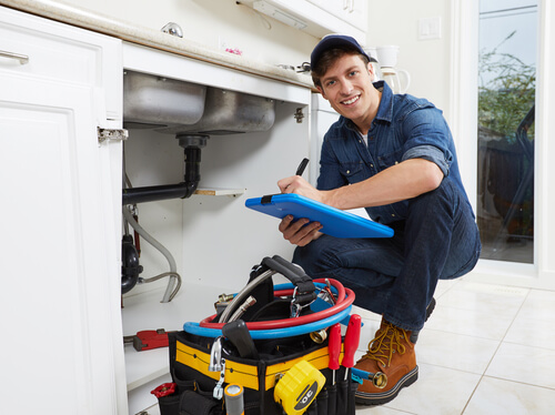 Licensed plumber working on pipe installation during a commercial renovation project