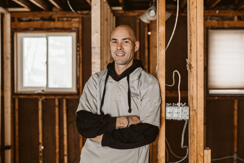 Happy homeowner shaking hands with a Poly-B Plumbing technician in front of their house