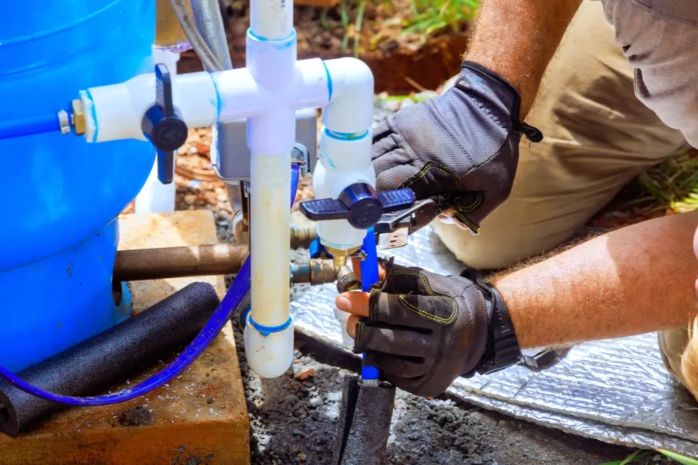 Homeowner inspecting a low water pressure issue linked to a faulty well pump system