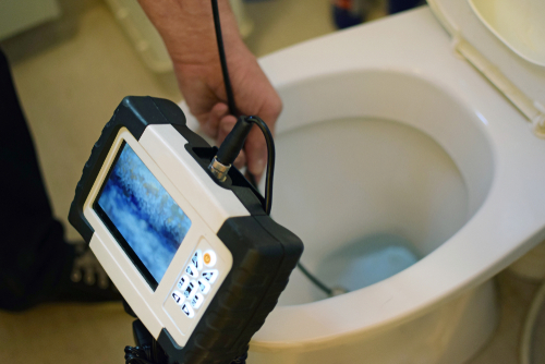 Poly-B Plumbing technician reviewing live footage from a video pipe inspection with a homeowner in North Bay